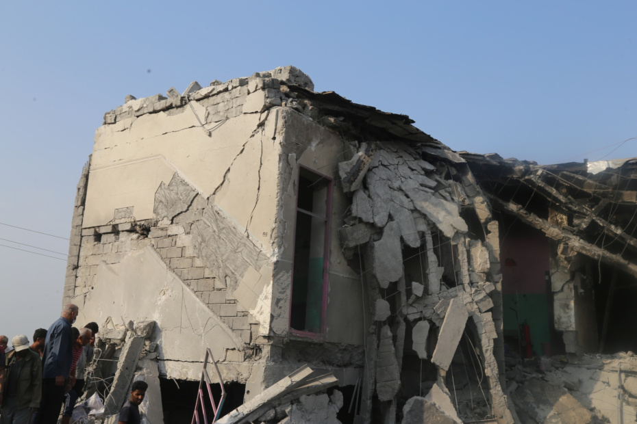 Люди стоят у поврежденного здания подвергшейся нападению начальной школы для девочек в Минабе