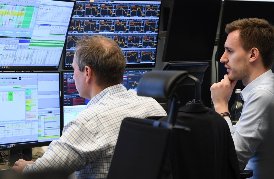 Биржевые трейдеры наблюдают за своими мониторами на торговой площадке фондовой биржи