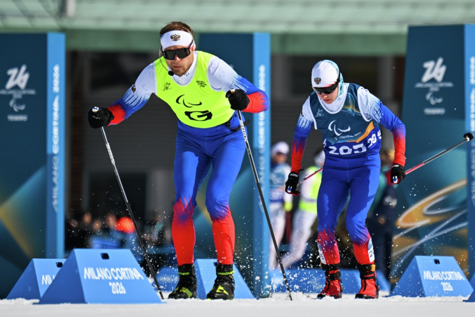 Спортсмен-ведущий Сергей Синякин и Анастасия Багиян (Россия) на дистанции спринта среди женщин на соревнованиях по лыжным гонкам XIV зимних Паралимпийских игр в Валь-ди-Фьемме