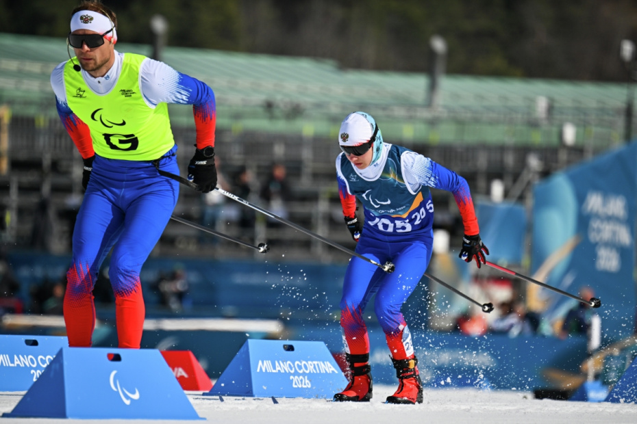 Спортсмен-ведущий Сергей Синякин и Анастасия Багиян (Россия) на дистанции спринта среди женщин на соревнованиях по лыжным гонкам XIV зимних Паралимпийских игр в Валь-ди-Фьемме