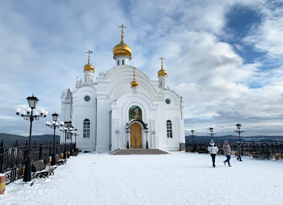 Люди гуляют возле церкви Серафима Саровского в городе Златоусте зимой