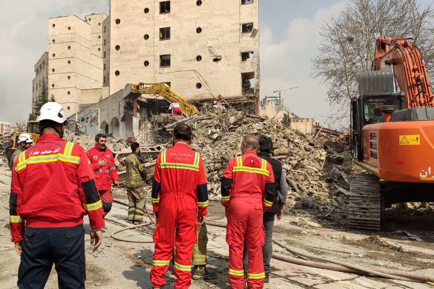 Тегеран, Иран: спасательные команды Иранского Красного Полумесяца работают на месте разрушения здания в результате авиаудара в Тегеране