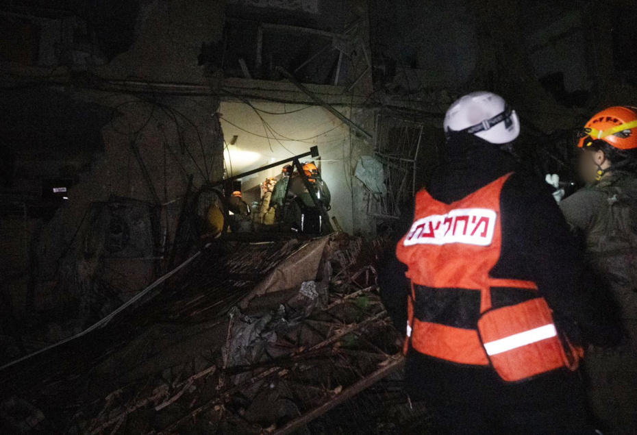 Спасатели на месте попадания иранской ракеты в Димоне 21 марта 2026 года