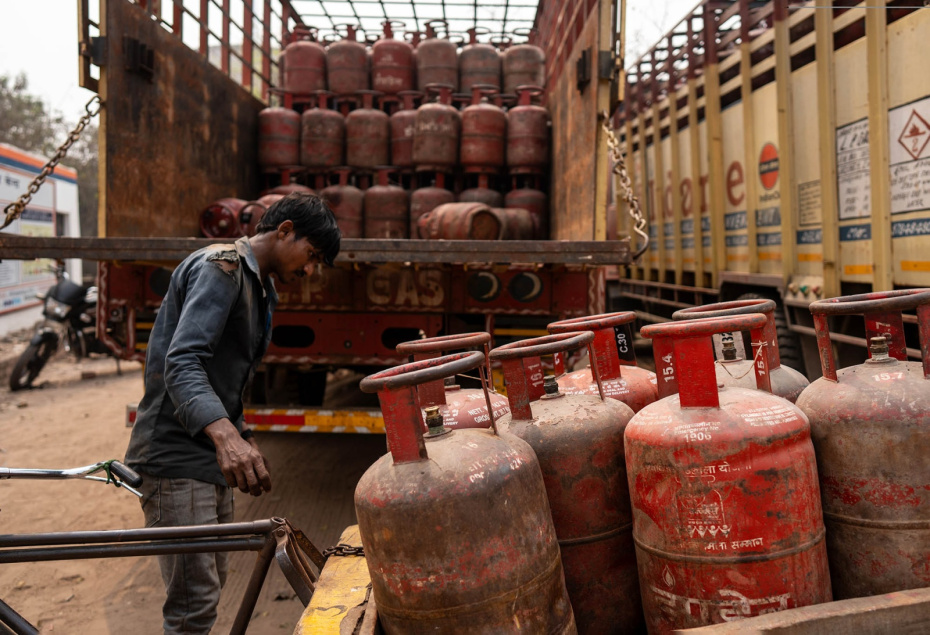 Рабочий загружает баллоны со сжиженным нефтяным газом (СНГ), Индия