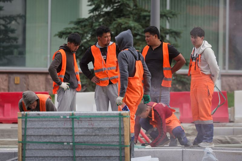 Рабочие укладывают тротуарную плитку