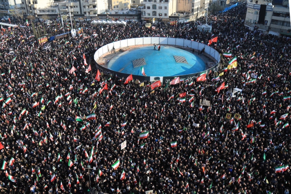 Демонстранты размахивают национальными флагами Ирана, собираясь на митинг в поддержку нового верховного лидера на площади Энгелаб в центре Тегерана