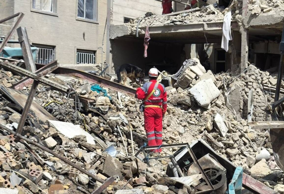 Тегеран, Иран: спасатель команды иранского Красного Полумесяца работает на месте разрушения здания в результате авиаудара в Тегеране