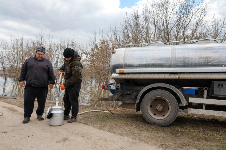 Мужчины наливают молоко в бидон из молоковоза в селе Заокское в Рязанской области.