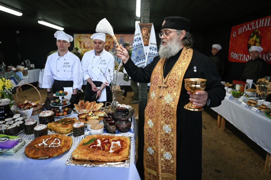 Полковой священник старший лейтенант Василий Зудилов (позывной Черномор) освящает пасхальные куличи и яйца в группировке войск «Центр» на Добропольском направлении СВО