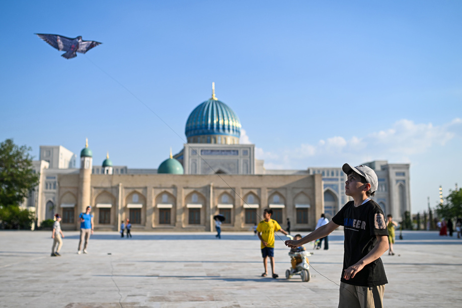 Ребенок запускает воздушного змея на площади в Ташкенте