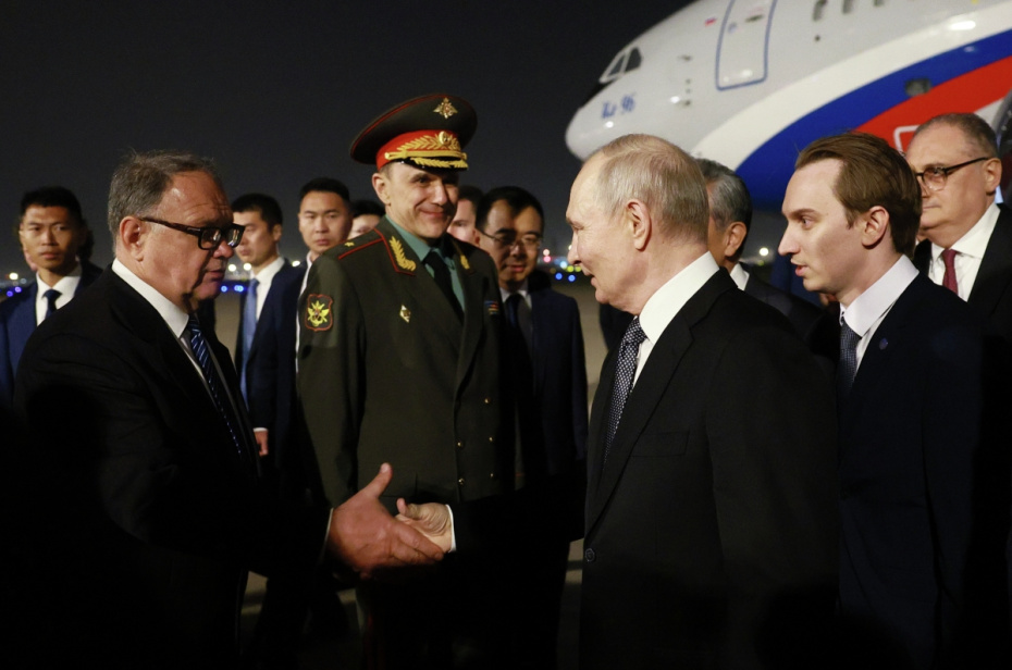 Владимир Путин и атташе по вопросам обороны генерал-майор Алексей Липилин в аэропорту Пекина, 19 мая 2026 года