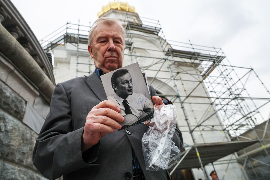 Фотография актера Михаила Ножкина в руках у мужчины перед церемонией прощания в Нижнем храме храма Христа Спасителя