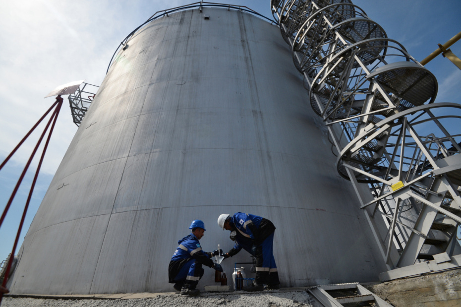 Сотрудники Новосибирской нефтебазы компании «Газпром нефть» отбирают пробу бензина из резервуара для контроля качества