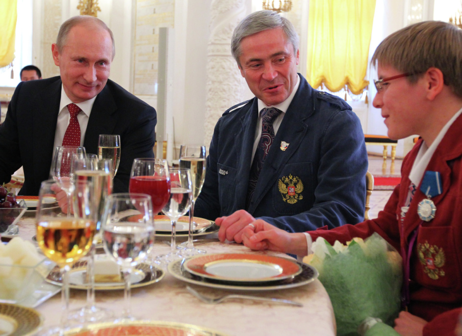 Владимир Путин, первый вице-президент Паралимпийского комитета России Павел Рожков и бегунья Елена Паутова (слева направо) после церемонии вручения государственных наград золотым призерам Паралимпийских летних игр в Лондоне в Александровском зале Большого Кремлевского дворца, 2012 год