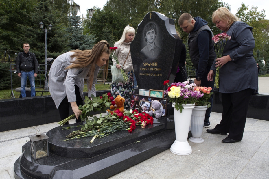 Люди возлагают цветы во время акции памяти членов хоккейного клуба «Локомотив»