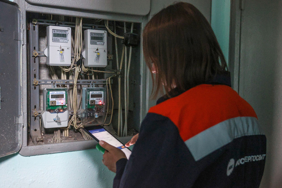 Сотрудница компании «Мосэнергосбыт» проводит поверку счетчиков учета электроэнергии в одном из жилых домов в Москве