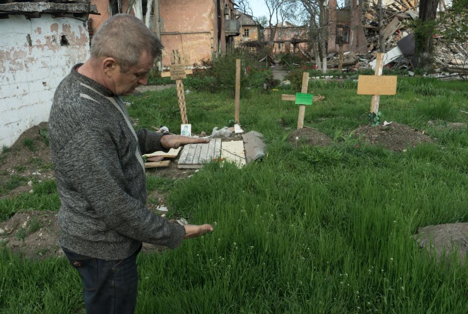 Мужчина возле захоронений во дворе дома