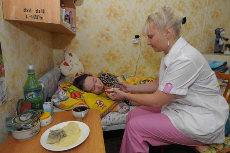 Патронажная сестра кормит лежачего больного в Челябинском доме-интернате №1 для престарелых и инвалидов