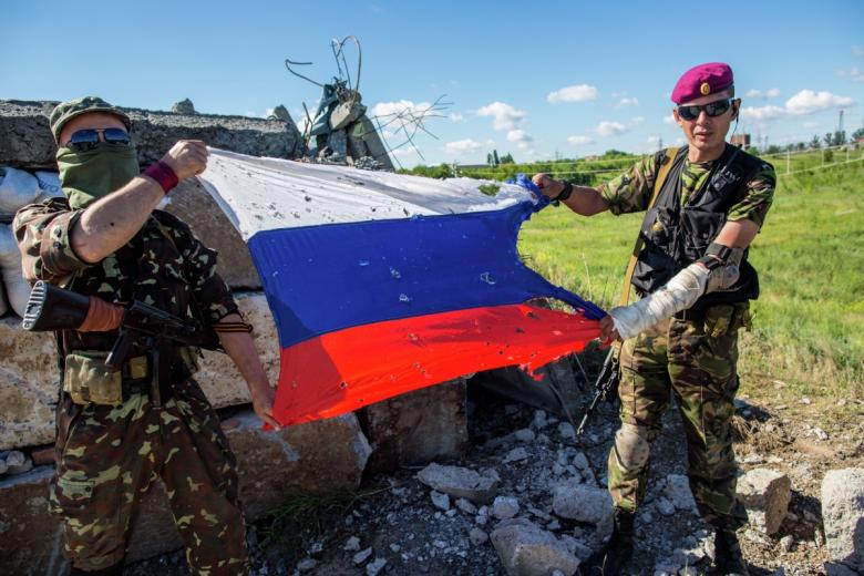 Ополченцы с флагом России, пробитым осколками, на блокпосту возле поселка Восточное под Славянском