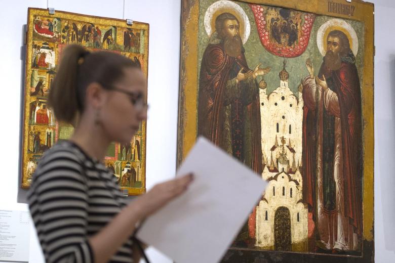 Посетитель у иконы «Преподобные Сергий и Никон Радонежские в молении Святой Троице»