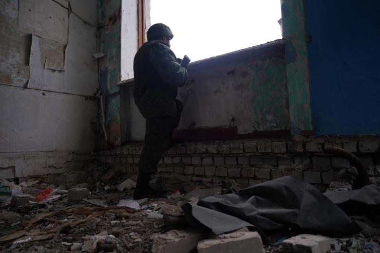 Военнослужащий ЛНР в разрушенной школе в посёлке Молодёжный, находящемся на линии боевого соприкосновения в Луганской области