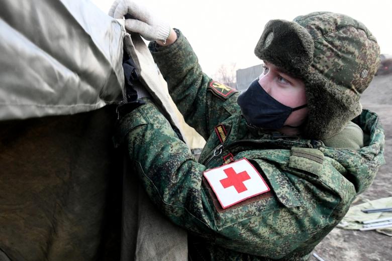 Военнослужащий устанавливает палатку мобильного полевого госпиталя