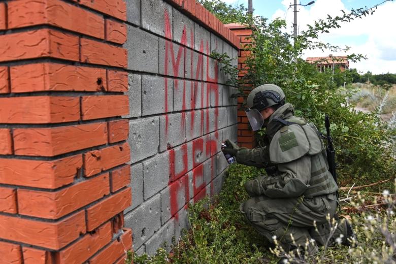 Сапер делает надпись «Мин нет» после проверки территории