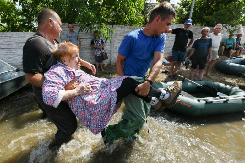 Волонтеры и спасатели МЧС проводят эвакуацию людей в городе Голая Пристань после подтопления