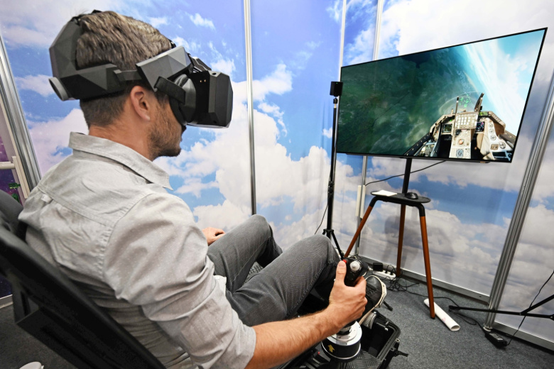 Мужчина  тестирует полет истребителя F16 с помощью летного тренажера