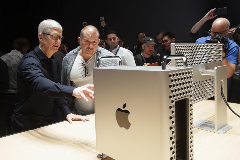 Глава компании Apple Тим Кук (слева) и главный дизайнер Apple Джонатан Айв (второй слева) у обновленного компьютера Mac Pro на презентации новых продуктов компании на конференции WWDC 2019