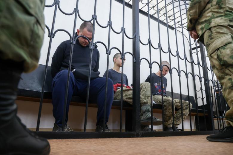Гражданин Великобритании Шон Пиннер, гражданин Марокко Саадун Брагим и гражданин Великобритании Эйден Эслин (слева направо), обвиняемые в участии в боевых действиях в составе украинских вооруженных формирований в качестве наемников