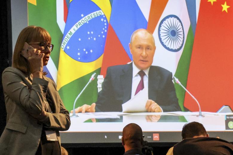Президент России Владимир Путин (на экране) участвует по видеосвязи в заседании саммита БРИКС