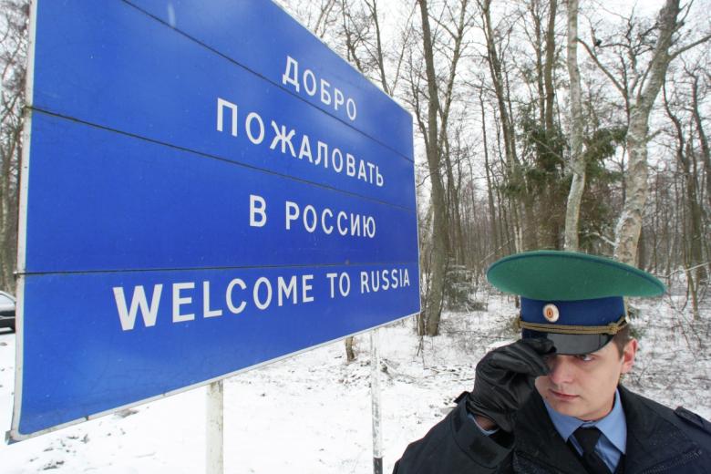 Пограничник у информационного щита «Добро пожаловать в Россию» на международном автомобильном пункте пропуска Морское — Нида, Калининградская область