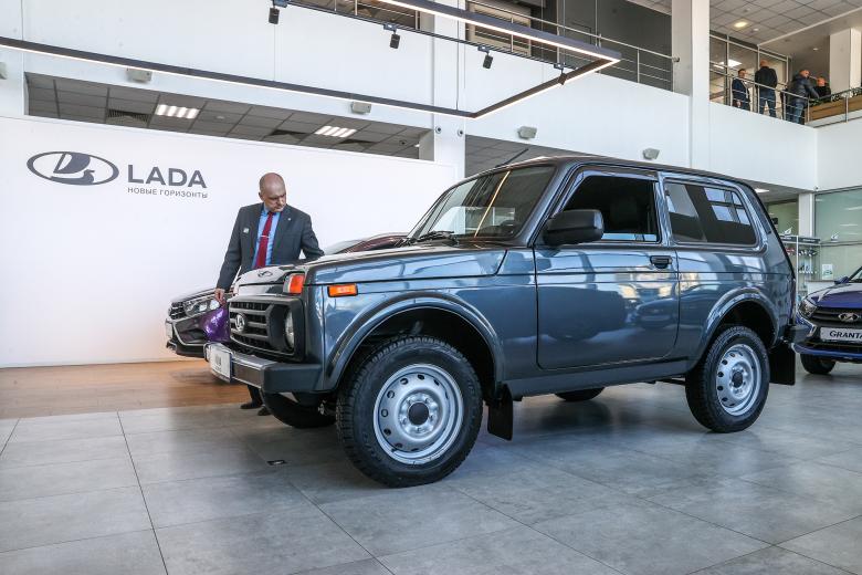 Посетитель осматривает автомобиль Lada Niva Legend в дилерском салоне Lada