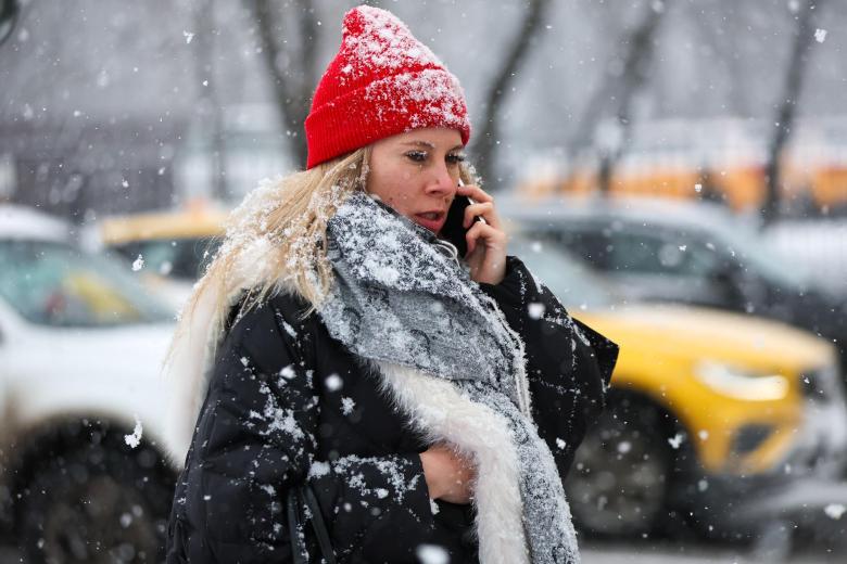 Женщина во время снегопада в Москве