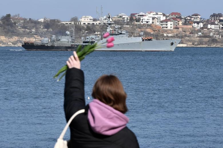 Девушка машет с набережной военному кораблю в Севастополе