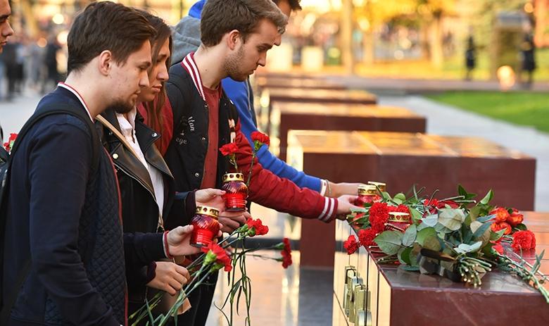 Люди несут цветы к памятнику городу-герою Керчи в Москве