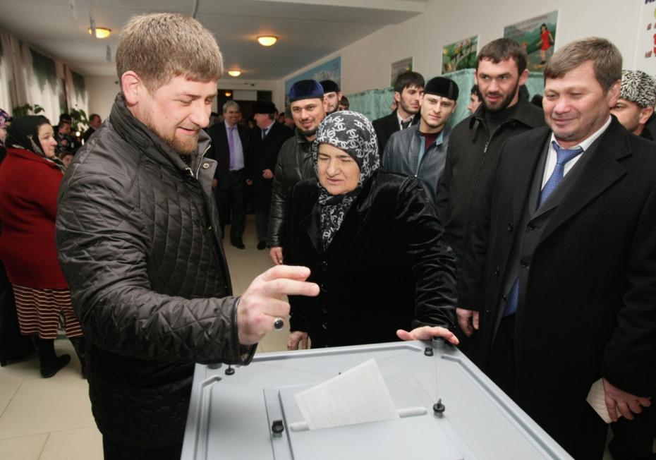 Глава Чеченской Республики Рамзан Кадыров (слева) опускает бюллетень в урну для голосования на избирательном участке № 167 в селе Центарой на выборах президента РФ. В центре — мать Рамзана Кадырова Аймани Кадырова