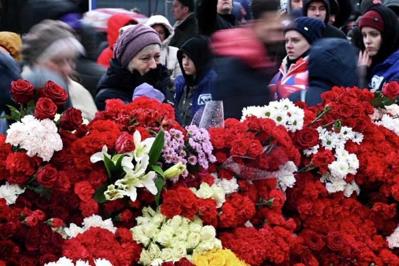 Люди у стихийного мемориала возле подмосковного «Крокус Сити Холла» в память о жертвах теракта