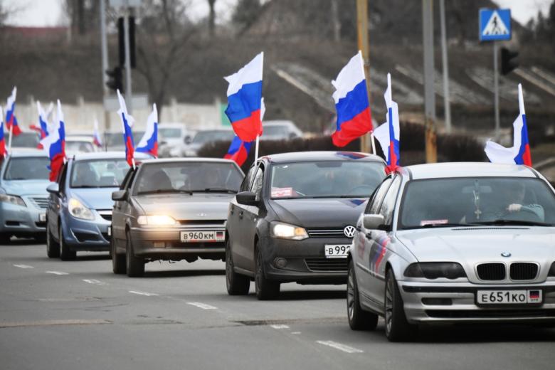 Люди едут на машинах с флагами России по улице Донецка