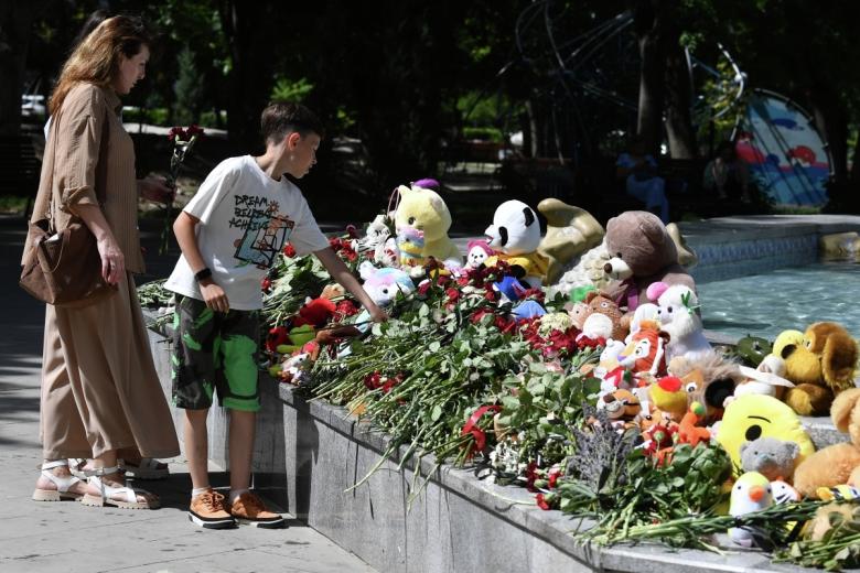Мальчик возлагает цветы к стихийному мемориалу в Комсомольском парке имени Марии Байды в Севастополе в день траура по погибшим в результате ракетной атаки Вооруженных сил Украины