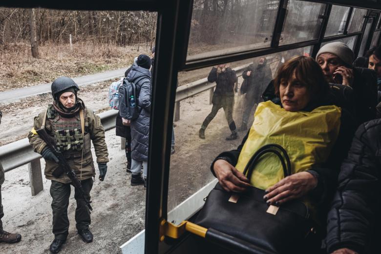 Солдат ВСУ возле автобуса с мирными жителями