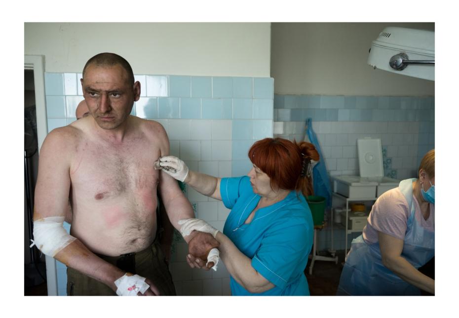 На верхнем этаже госпиталя проводят операцию. Врачи зашивают раны и вытаскивают осколки