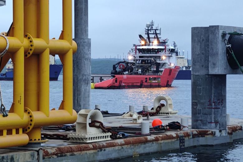 Буксир выводит платформу по производству сжиженного газа из сухого дока