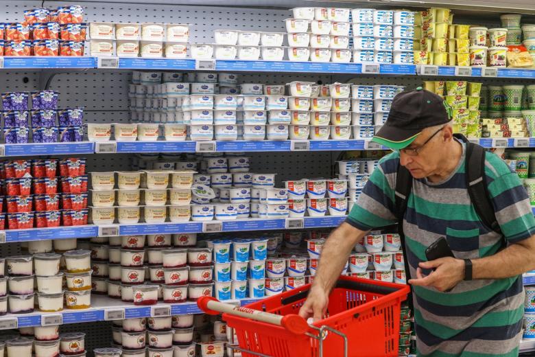 Покупатель выбирает продукты в молочном отделе гипермаркета «Ашан»