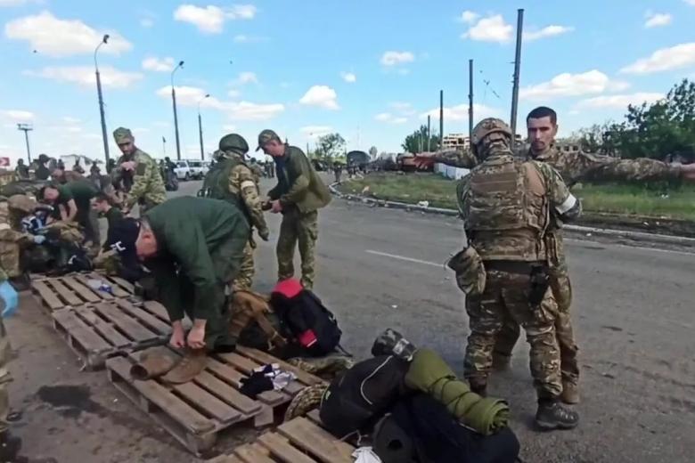 Российские военнослужащие досматривают сдавшихся в плен украинских военнослужащих и боевиков националистического батальона «Азов»