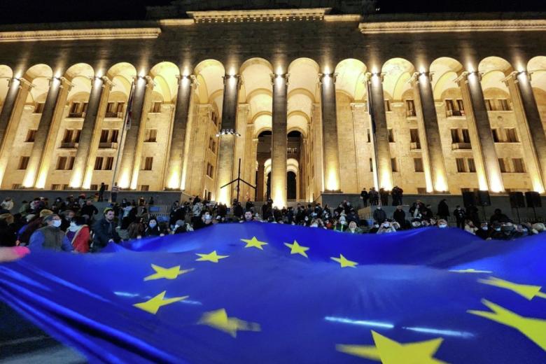 Участники акции протеста разворачивают флаг Евросоюза у здания парламента Грузии в центре Тбилиси