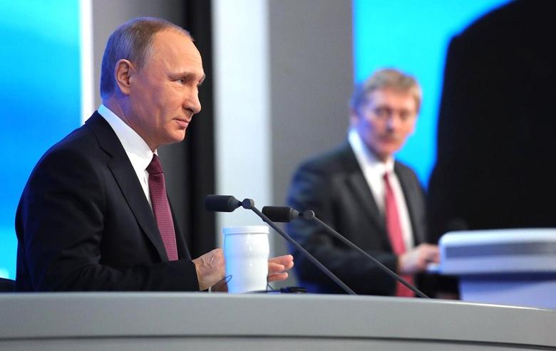 Президент РФ Владимир Путин, глава пресс-службы Кремля Дмитрий Песков на втором плане