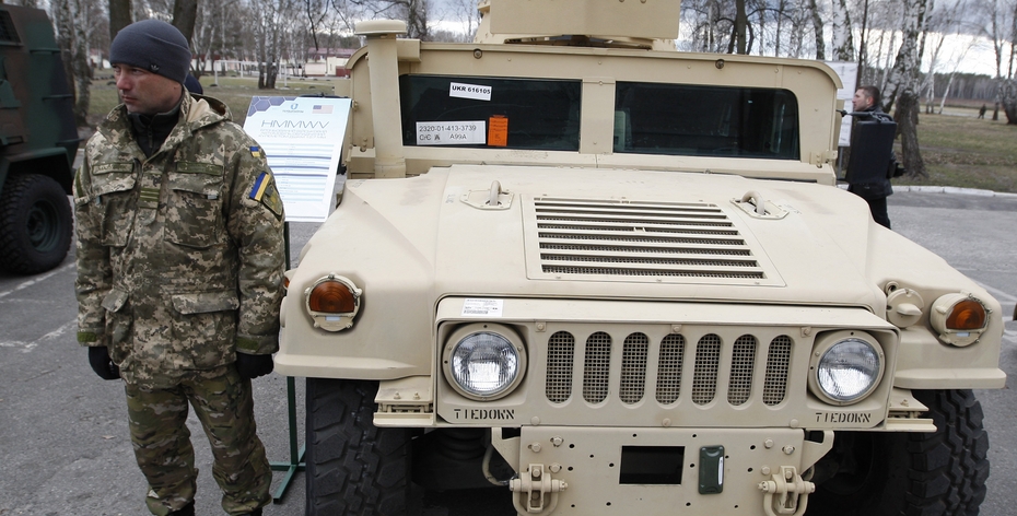 Военнослужащий Национальной гвардии Украины стоит возле бронетранспортера Хамви 