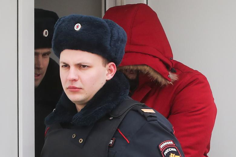 Сотрудники полиции выводят подозреваемого в нападении на прихожан храма Святителя Николая на Бакунинской улице